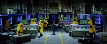 Movie still from “A Shaun the Sheep Movie: Farmageddon” (2019), directed by Will Becher – A group of people in yellow suits and a man in a black suit; Wide shot, High angle