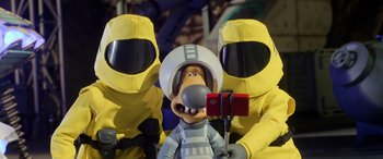 Movie still from “A Shaun the Sheep Movie: Farmageddon” (2019), directed by Will Becher – A couple of people in yellow suits taking a picture of a cartoon character; Close Up shot, Overhead angle