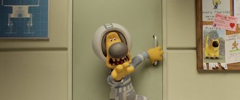 Movie still from “A Shaun the Sheep Movie: Farmageddon” (2019), directed by Will Becher – A toy dog in a space suit is holding on to a door handle; Medium shot, High angle