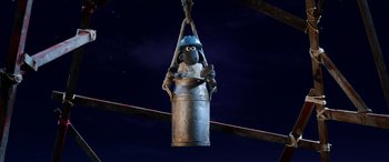 Movie still from “A Shaun the Sheep Movie: Farmageddon” (2019), directed by Will Becher – A statue of a sheep hanging from a metal pole; Wide shot, Overhead angle