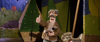 Movie still from “A Shaun the Sheep Movie: Farmageddon” (2019), directed by Will Becher – A man in a brown jacket holding a pair of scissors; Medium shot, Low angle