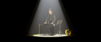 Movie still from “A Shaun the Sheep Movie: Farmageddon” (2019), directed by Will Becher – A boy is playing a keyboard in the spotlight; Medium shot, High angle