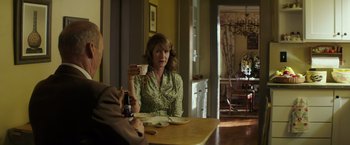 Movie still from “The Founder” (2016), directed by John Lee Hancock – A woman sitting at a table holding a cup of coffee; Medium shot, Over the shoulder angle