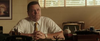 Movie still from “The Founder” (2016), directed by John Lee Hancock – A man sitting at a table with his hands clasped together; Close Up shot, Low angle