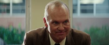 Movie still from “The Founder” (2016), directed by John Lee Hancock – An older man in a brown suit and tie; Close Up shot, Over the shoulder angle