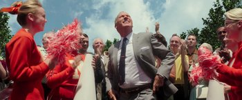 Movie still from “The Founder” (2016), directed by John Lee Hancock – A group of people standing next to each other on a sunny day; Medium shot, Low angle