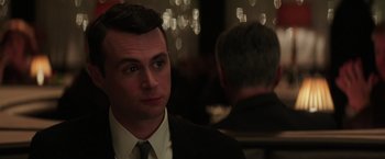 Movie still from “The Founder” (2016), directed by John Lee Hancock – A person wearing a suit and tie; Close Up shot, Over the shoulder angle