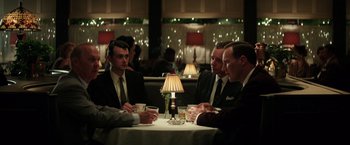 Movie still from “The Founder” (2016), directed by John Lee Hancock – A group of men sitting at a table in a restaurant; Medium shot, Over the shoulder angle