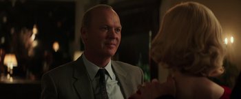 Movie still from “The Founder” (2016), directed by John Lee Hancock – A man in a suit and tie talking to a woman; Close Up shot, Over the shoulder angle