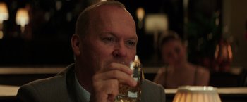 Movie still from “The Founder” (2016), directed by John Lee Hancock – A person holding a drink in his hand; Close Up shot, Over the shoulder angle