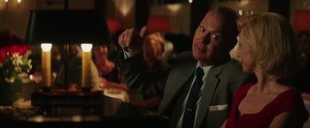 Movie still from “The Founder” (2016), directed by John Lee Hancock – A man in a suit and tie giving a thumbs up; Close Up shot, Over the shoulder angle