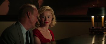 Movie still from “The Founder” (2016), directed by John Lee Hancock – A woman in a red dress sitting next to a man; Close Up shot, Over the shoulder angle