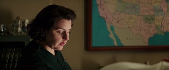 Movie still from “The Founder” (2016), directed by John Lee Hancock – A woman is looking down at a map of the united states; Medium shot, Low angle