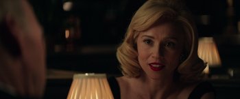 A woman with blonde hair and red lipstick looking at the camera