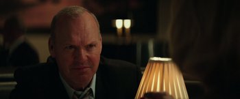 Movie still from “The Founder” (2016), directed by John Lee Hancock – An older man sitting in front of a table lamp; Close Up shot, Over the shoulder angle