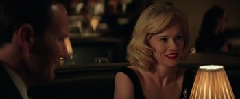 Movie still from “The Founder” (2016), directed by John Lee Hancock – A woman with blonde hair sitting at a table; Close Up shot, Over the shoulder angle