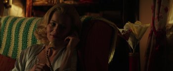 Movie still from “The Founder” (2016), directed by John Lee Hancock – A woman sitting in a chair talking on a cell phone; Close Up shot, Low angle