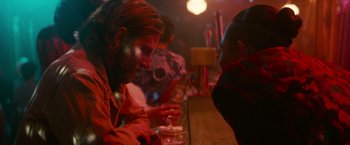 Movie still from “A Star Is Born” (2018), directed by Bradley Cooper – A group of people sitting at a bar drinking beer; Close Up shot, Over the shoulder angle