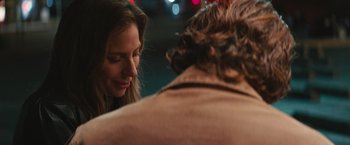 Movie still from “A Star Is Born” (2018), directed by Bradley Cooper – A woman looking at a man in a brown jacket; Close Up shot, Over the shoulder angle