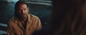 Movie still from “A Star Is Born” (2018), directed by Bradley Cooper – A man with a beard wearing a brown jacket; Close Up shot, Over the shoulder angle