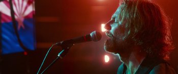 Movie still from “A Star Is Born” (2018), directed by Bradley Cooper – A man with a beard is singing into a microphone; Close Up shot, Low angle
