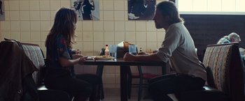 Movie still from “A Star Is Born” (2018), directed by Bradley Cooper – A man and a woman are sitting at a table; Medium shot, Over the shoulder angle