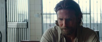Movie still from “A Star Is Born” (2018), directed by Bradley Cooper – A person with a beard looking at the camera; Close Up shot, Over the shoulder angle
