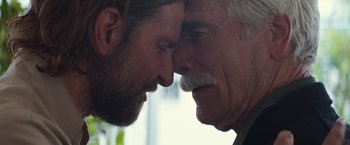 Movie still from “A Star Is Born” (2018), directed by Bradley Cooper – Two men face to face with one of them touching the other's face; Close Up shot, Over the shoulder angle