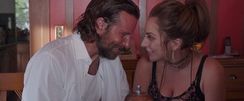 Movie still from “A Star Is Born” (2018), directed by Bradley Cooper – A man and a woman sitting next to each other at a table; Close Up shot, Over the shoulder angle