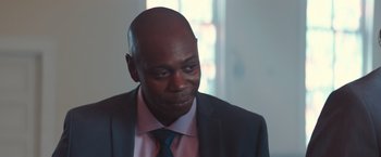 Movie still from “A Star Is Born” (2018), directed by Bradley Cooper – A man in a suit and tie looking down; Close Up shot, Over the shoulder angle