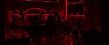 Movie still from “A Star Is Born” (2018), directed by Bradley Cooper – A group of people sitting in a dark room; Wide shot, High angle