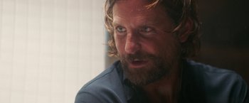 Movie still from “A Star Is Born” (2018), directed by Bradley Cooper – A person with long hair and a beard; Close Up shot, Over the shoulder angle