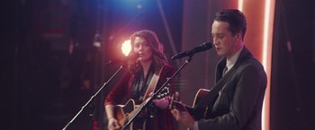 Movie still from “A Star Is Born” (2018), directed by Bradley Cooper – A man and a woman are playing guitar and singing; Medium shot, Over the shoulder angle