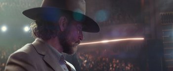 Movie still from “A Star Is Born” (2018), directed by Bradley Cooper – A man with a beard wearing a cowboy hat in front of an audience; Close Up shot, Low angle