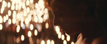 Movie still from “A Star Is Born” (2018), directed by Bradley Cooper – A woman with a piercing in her ear looking up at the lights; Close Up shot, Low angle