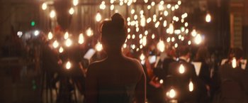 Movie still from “A Star Is Born” (2018), directed by Bradley Cooper – A woman is standing in front of a group of people; Extreme Wide shot, Over the shoulder angle