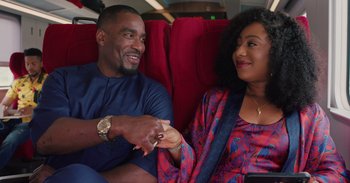 A man and a woman sitting next to each other on a train