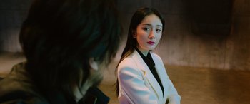 Movie still from “A Writer's Odyssey” (2021), directed by Yang Lu – A woman in a white jacket and a man in a black tie; Close Up shot, Over the shoulder angle