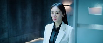 Movie still from “A Writer's Odyssey” (2021), directed by Yang Lu – A woman wearing a white suit and black shirt; Close Up shot, Low angle