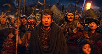 Movie still from “A Writer's Odyssey” (2021), directed by Yang Lu – A group of people dressed in costumes and masks; Medium shot, High angle