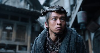 Movie still from “A Writer's Odyssey” (2021), directed by Yang Lu – A man wearing a hat and a sweater; Close Up shot, Low angle