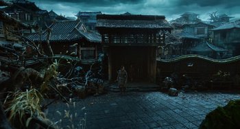 Movie still from “A Writer's Odyssey” (2021), directed by Yang Lu – A man standing in front of an old building; Extreme Wide shot, High angle