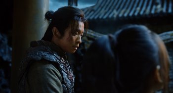 Movie still from “A Writer's Odyssey” (2021), directed by Yang Lu – A woman with a long black hair tied in a bun looking to her left; Close Up shot, Over the shoulder angle