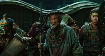 Movie still from “A Writer's Odyssey” (2021), directed by Yang Lu – An old man with a hat holding an umbrella; Medium shot, Low angle