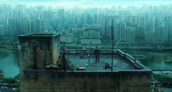 Movie still from “A Writer's Odyssey” (2021), directed by Yang Lu – Two people standing on a rooftop looking out over a city; Extreme Wide shot, High angle