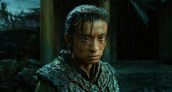 A young man with wet hair is wearing a costume