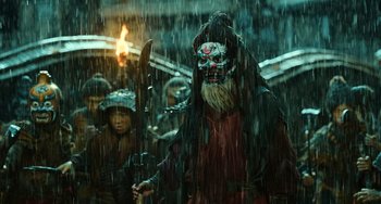 Movie still from “A Writer's Odyssey” (2021), directed by Yang Lu – A man with a mask on in the rain; Medium shot, Low angle