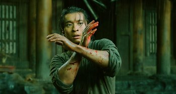 Movie still from “A Writer's Odyssey” (2021), directed by Yang Lu – A man with blood on his hands and face; Medium shot, Low angle