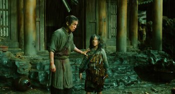 Movie still from “A Writer's Odyssey” (2021), directed by Yang Lu – A man and a boy are standing next to each other; Medium shot, Low angle