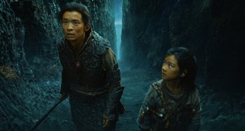 Movie still from “A Writer's Odyssey” (2021), directed by Yang Lu – A man and a woman walking through a forest; Medium shot, Low angle